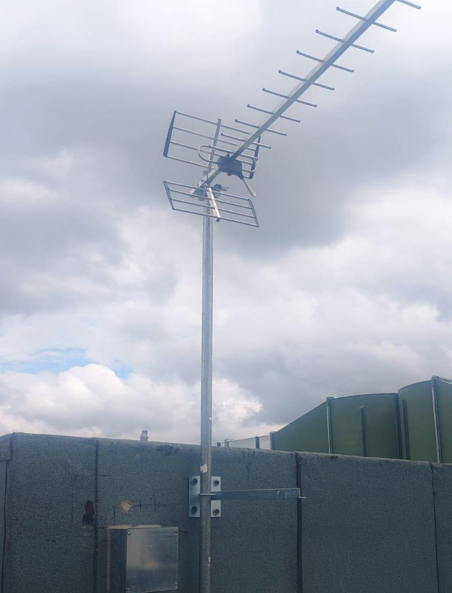 Antena de televisión de libre recepción montada en un mástil sobre la cubierta del edificio