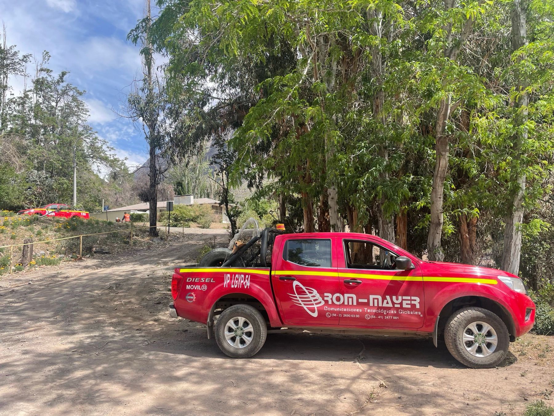 Camioneta de Rom Mayer estacionada en el camino interior del campamento, entre eucaliptos